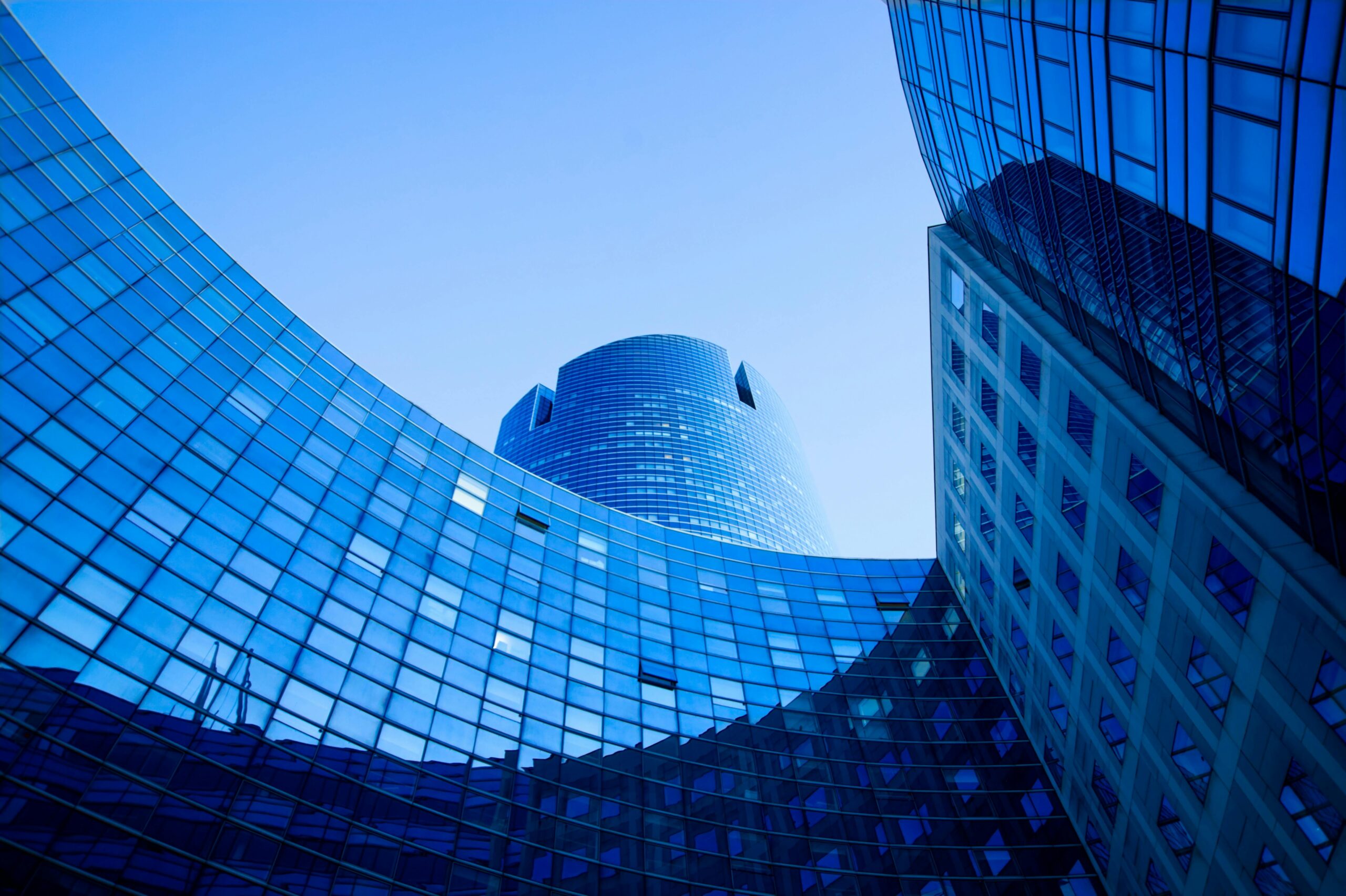 Stunning view of modern skyscraper with reflective glass panels under a clear blue sky.